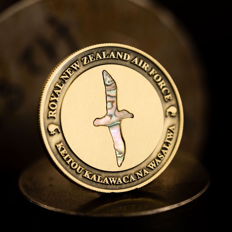 Custom Royal New Zealand Air Force (RNZAF) challenge coin in antique gold finish, with paua insert in the shape of a bird. 
